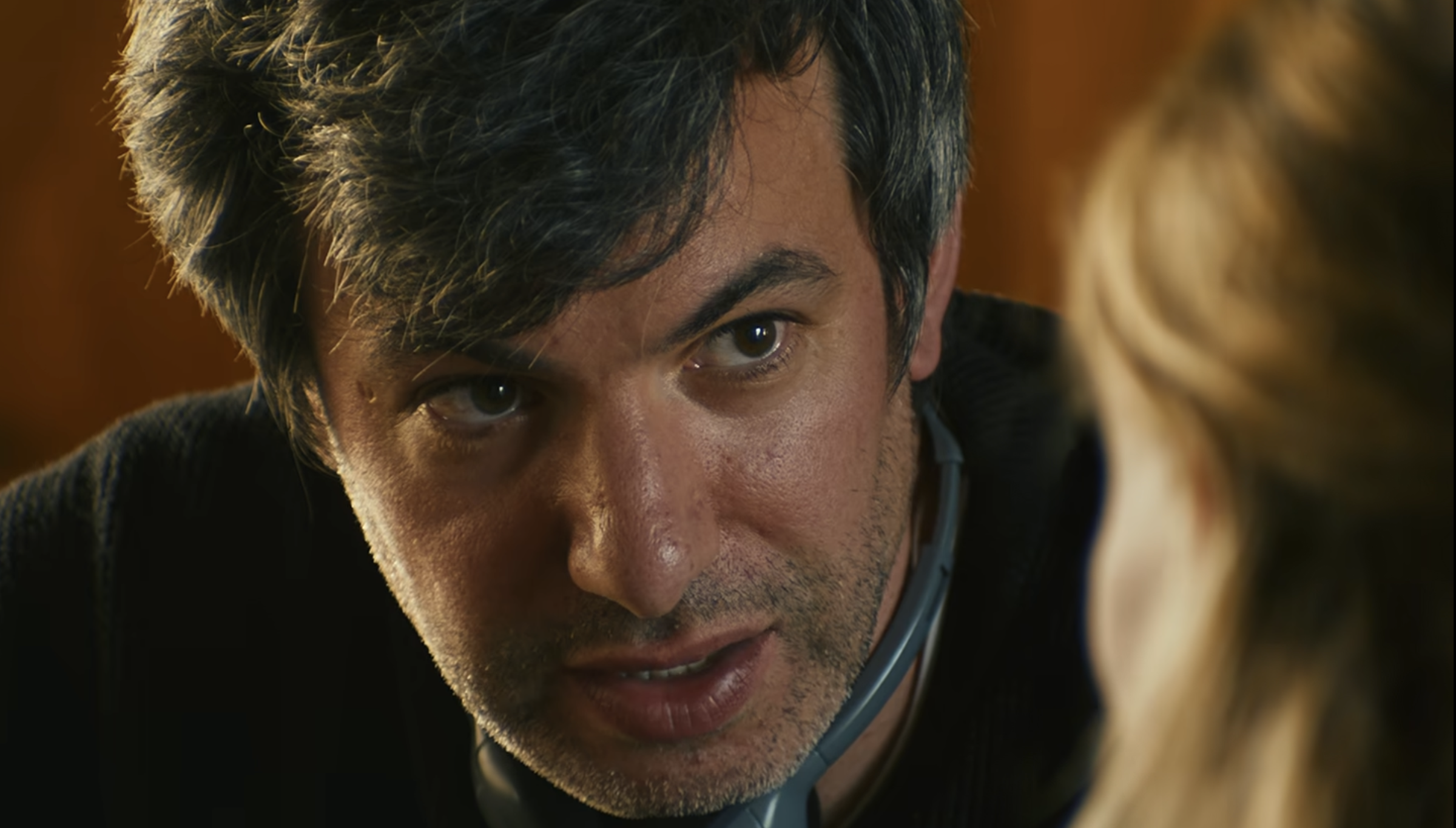 You Can See Everything Review: The Truth Is Not As Simple As It Seems Man in a black sweater staring at a blonde woman